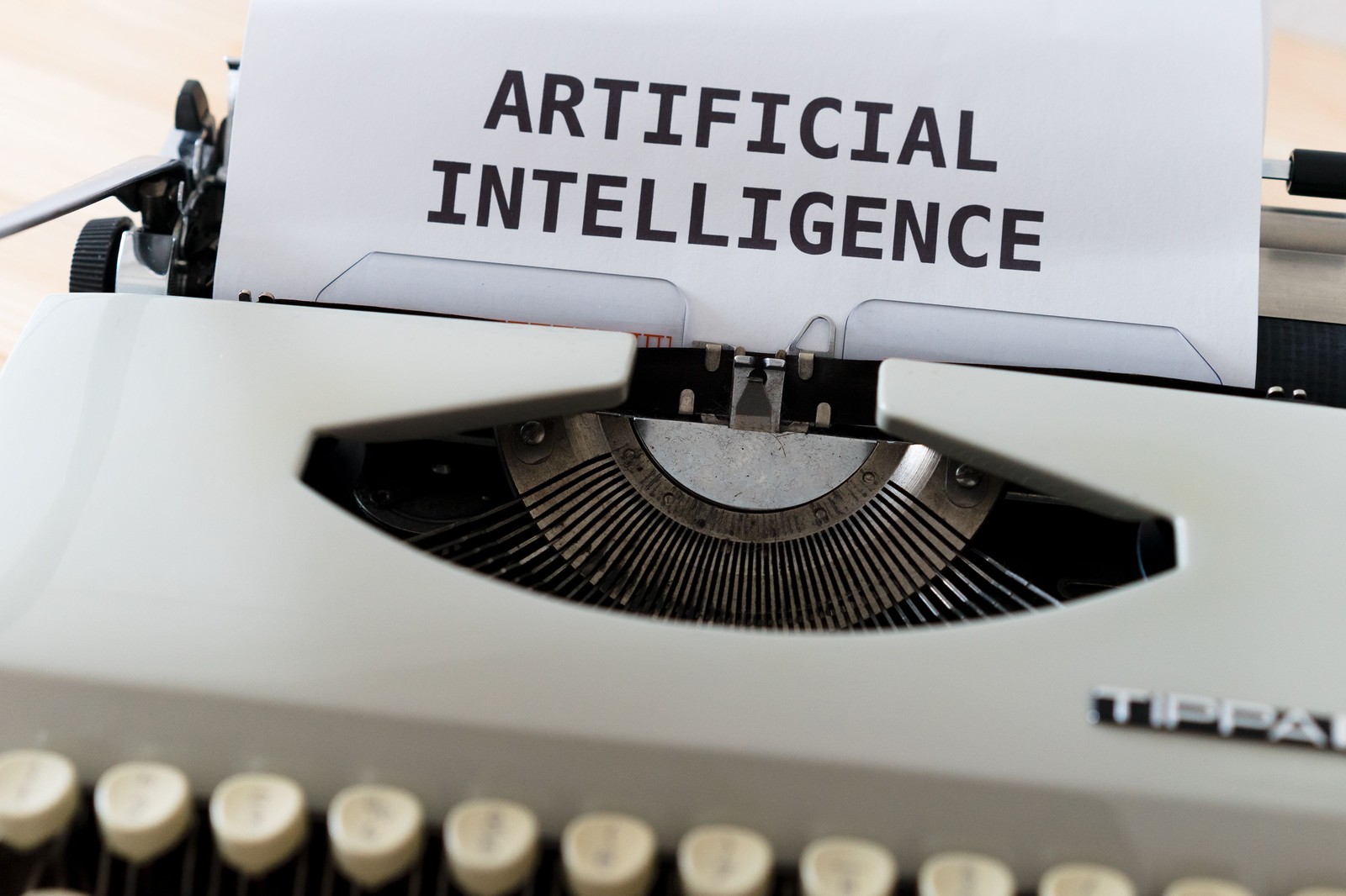 Máy đánh chữ với tờ giấy in dòng chữ ARTIFICIAL INTELLIGENCE