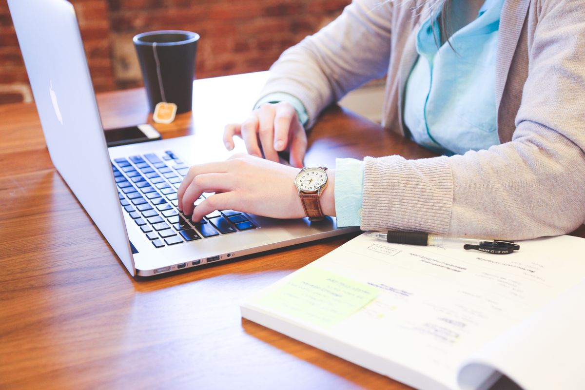 Không gian làm việc với laptop và sổ tay khi áp dụng quy trình viết content chuẩn SEO