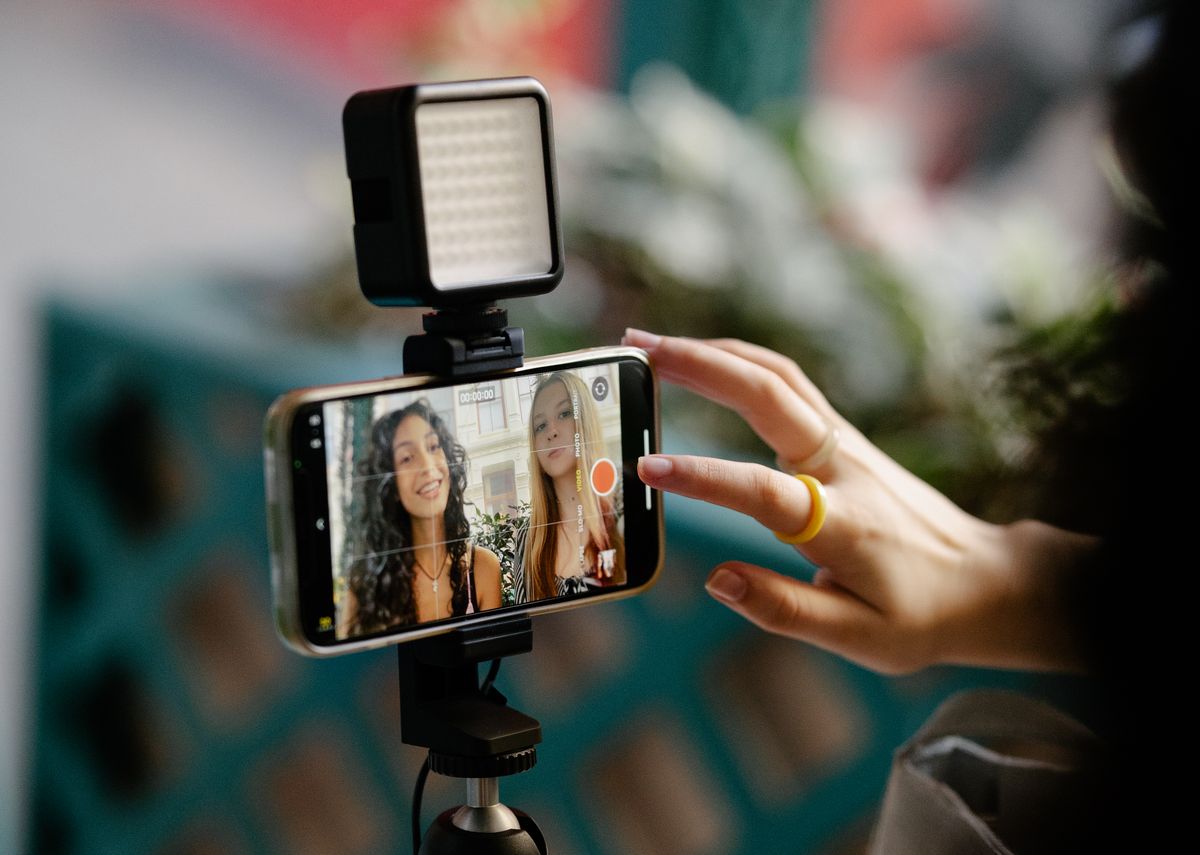 Hai người quay video bán hàng bằng điện thoại với đèn LED