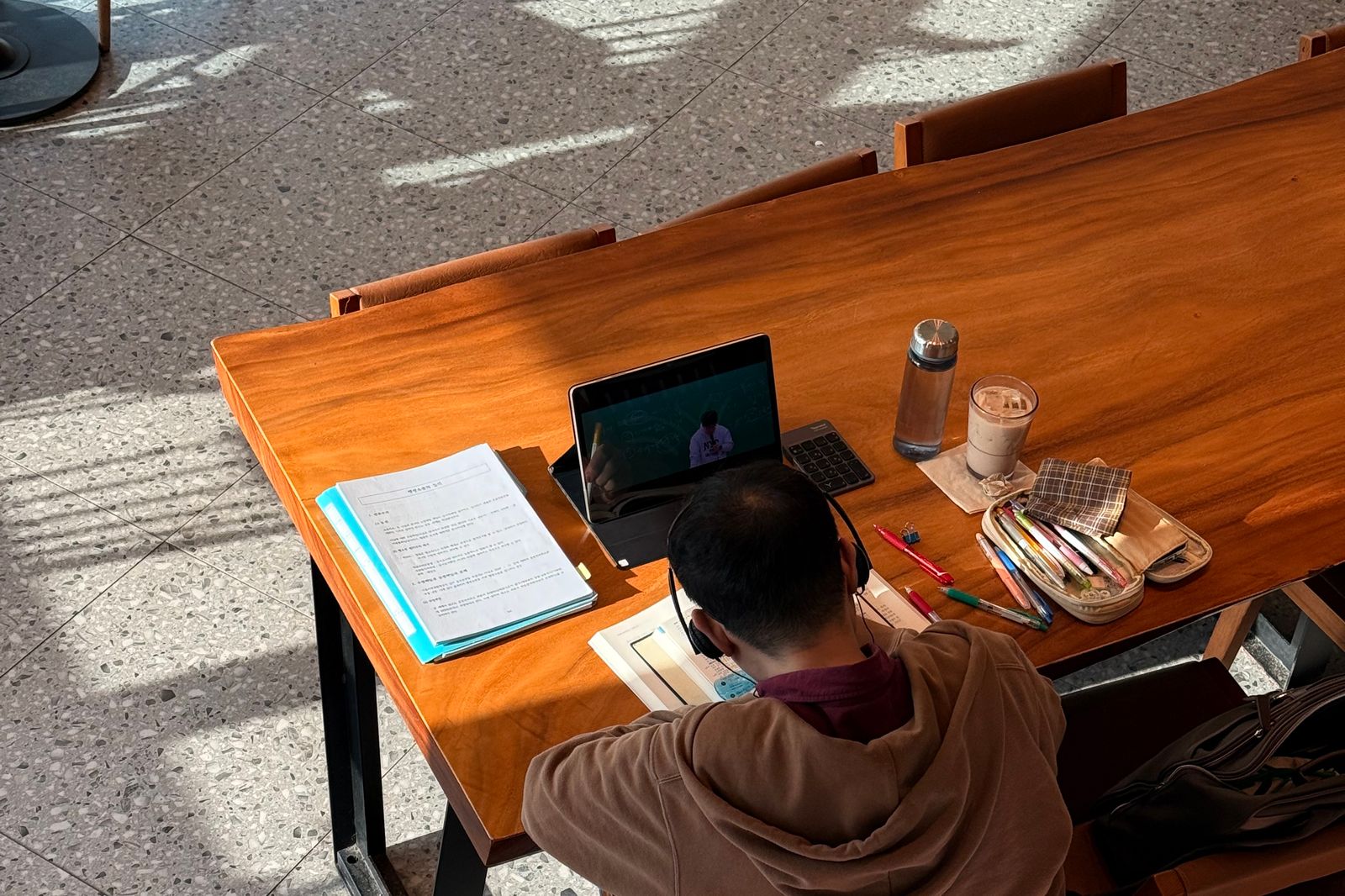 Người dùng nghiên cứu tài liệu cùng laptop và sổ ghi chú